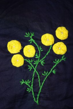 sarı ve yeşil renkli yünlü el işi kumaş üzerine daire şeklinde işlemeler.