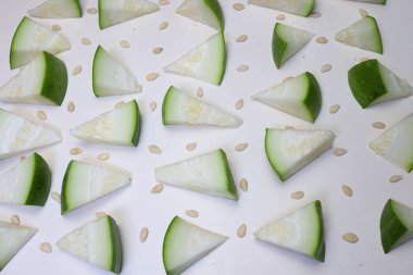 Beyaz arkaplanda tohumları olan balmumu kabağı dilimi