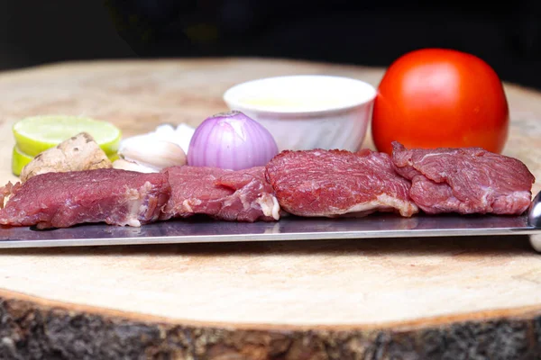 cow beef with spice and sliced lemon and tomato on chopping board