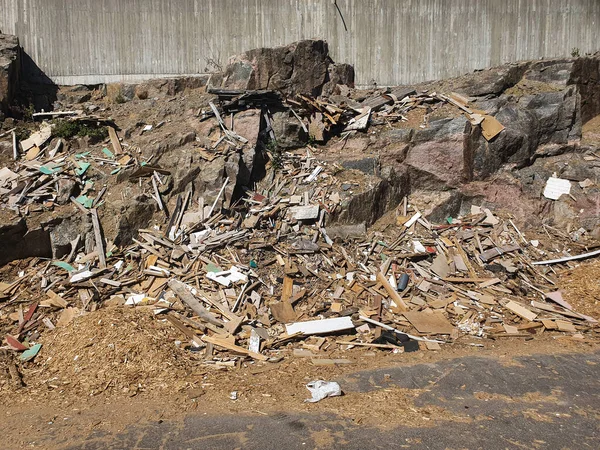 Un mur de pierre dans une décharge. déchets de bois dans une décharge. — Photo