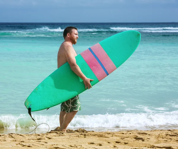 Surfer with surfboard in the ocean