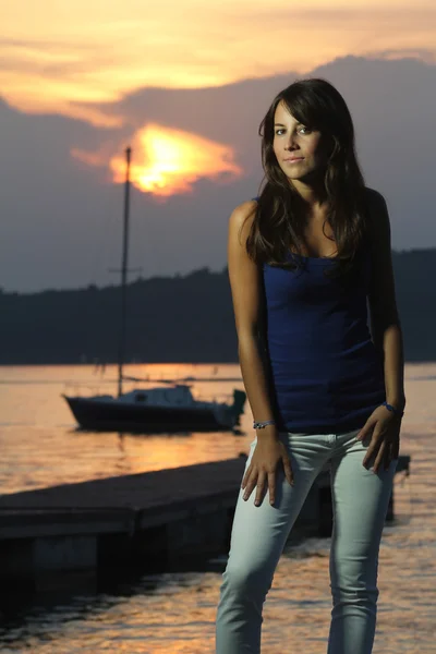 Mooi meisje poseren in sterke zonsondergang licht — Stockfoto