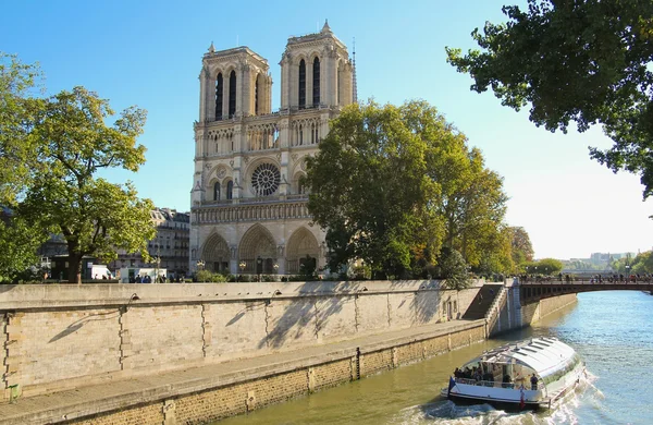 Notre dame i paris och turist båt på floden seine — Stockfoto