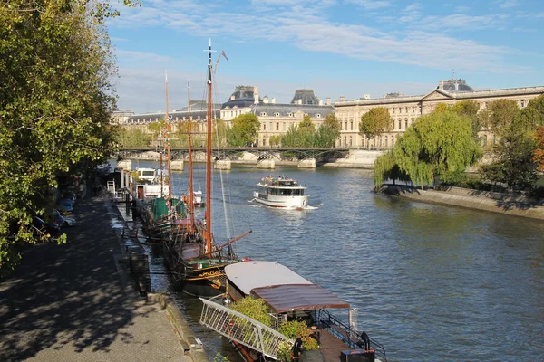 Seine river docks and boats with Louvre Museum in bakground — Stock Photo, Image