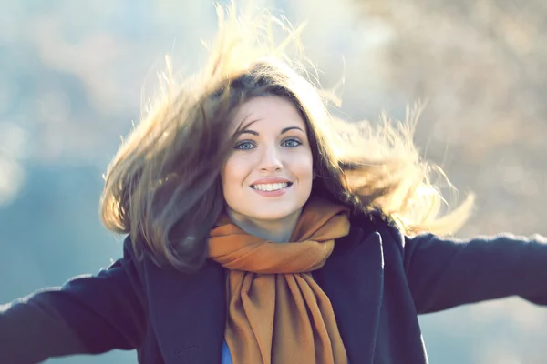 Beautiful smiling girl with long hairs in motion — Stock Photo, Image