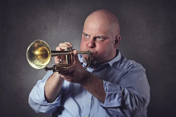 L'uomo con una forte espressione suona una tromba — Foto Stock