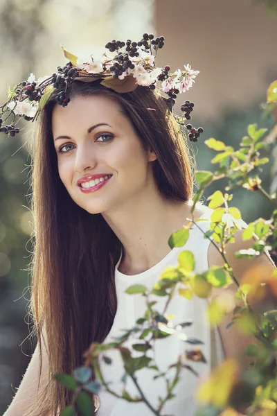 Ritratto di una bella ragazza sorridente con corona di fiori — Foto Stock