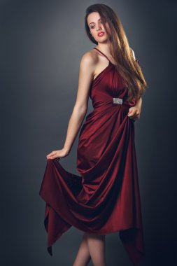 şık moda model kırmızı ipek elbise ile poz veriyor.