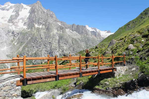 Hiking girl on a mountain bridge — Stock Photo, Image