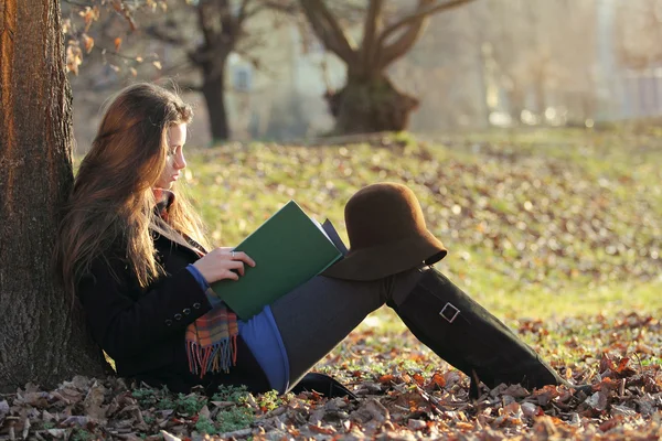 Young beautiful woman reading a book at the park — Stock Photo, Image