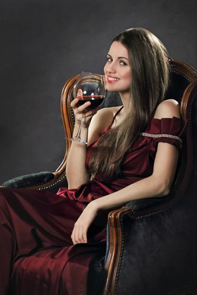 Sorrindo mulher atraente posa com um copo de vinho tinto — Fotografia de Stock