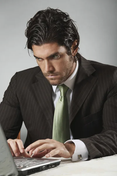 Handsome businessman looks at portable computer — Stock Photo, Image