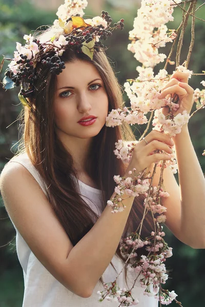 Belle jeune femme parmi les fleurs de cerisier — Photo