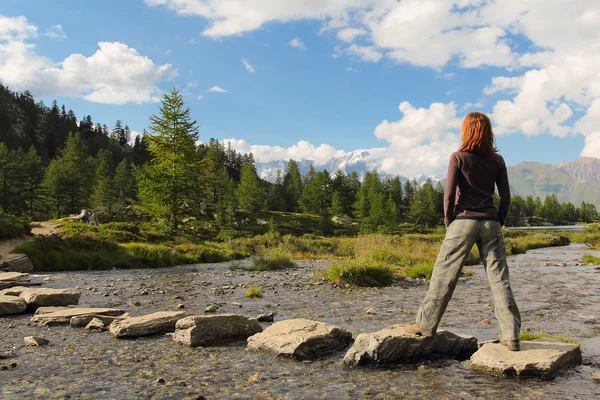 Randonneuse fille pose sur les pierres de ruisseau — Photo