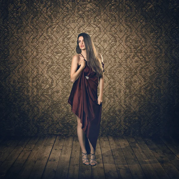 Hermosa modelo en vestido de seda rojo y fondo vintage — Foto de Stock