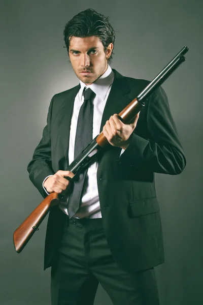 Fashion bodyguard poses with shotgun — Stock Photo, Image