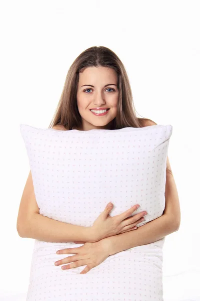 Beautiful girl smiles and embraces her pillow — Stock Photo, Image