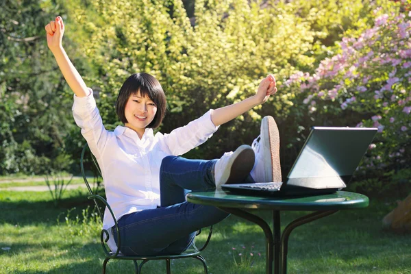 Happy student using laptop in the garden — Stock Photo, Image