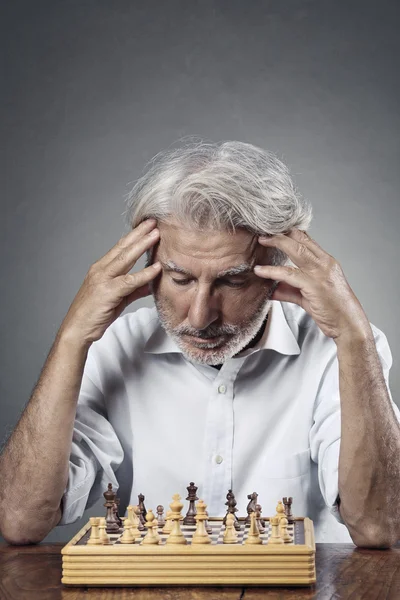 Uomo anziano che studia la scacchiera — Foto Stock