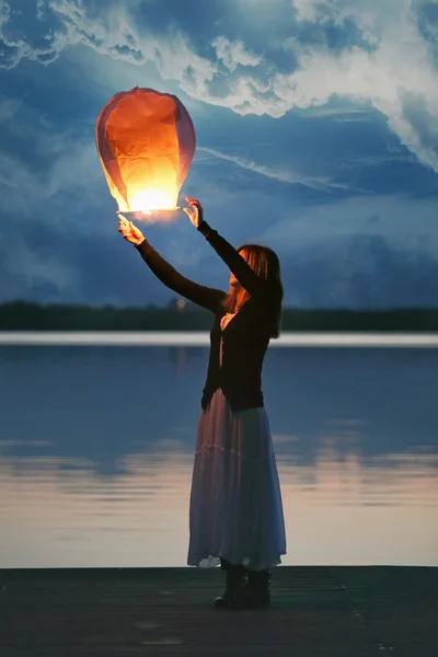 Chinese sky lantern and young woman at dusk — Stock Photo, Image