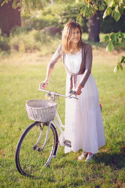 Vieux vélo et jolie jeune femme — Photo