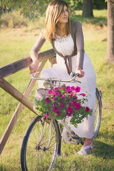 Femme sur un vélo vintage avec des fleurs — Photo