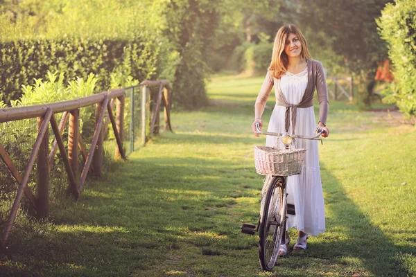 젊은 여 자가 그녀의 오래 된 자전거와 함께 웃 고 — 스톡 사진