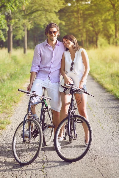 Divertente giovane coppia con biciclette — Foto Stock