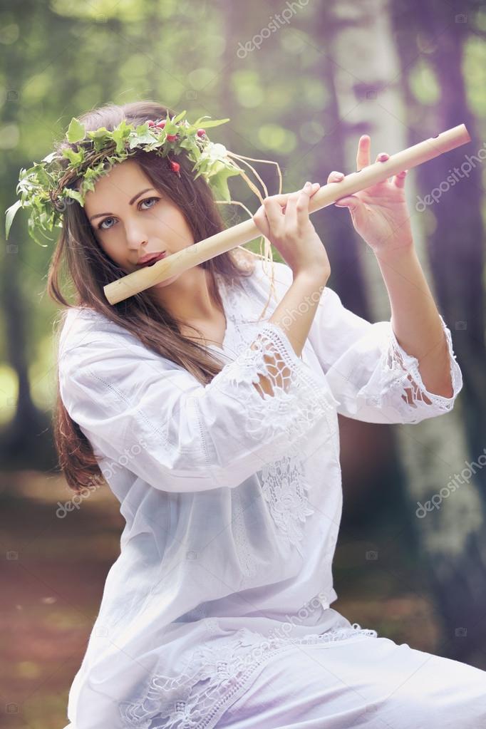 Beautiful forest nymph with a flute