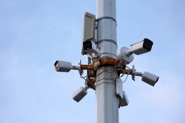 Mavi gökyüzündeki beton bir direkteki güvenlik kameraları. Kamera, güvenlik, mahremiyet ve suça karşı koruma kavramı