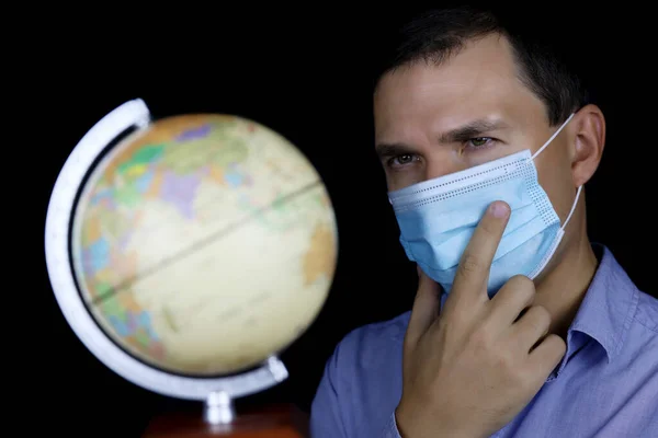 Pensiv Man Skyddande Ansiktsmask Ser Världen Manligt Porträtt Svart Bakgrund — Stockfoto