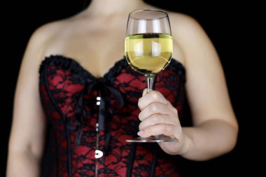 Glass of white wine in hand of sensual woman in red lace corset. Seductive female lingerie for celebration or romantic sex date