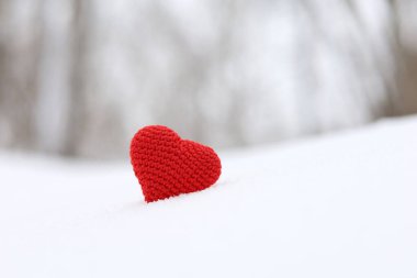 Aşk kalbi, sevgililer günü kartı, kırmızı örülmüş tutku sembolü ormanda karlar üzerinde. Romantik olay, kutlama ya da kış havası kavramı