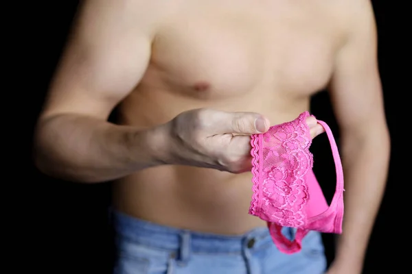 女のパンティーを手にした裸の胴を持つ筋肉質の男 セクシーランジェリーのためにロマンチックなデート — ストック写真