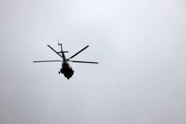 Rus helikopterinin silueti gri arka planda uçuyor