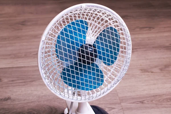 Small fan on the wooden floor closeup — Stock Photo, Image