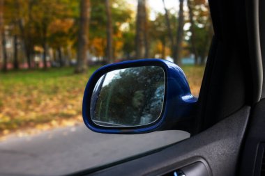 Sonbahar yolunun arka planındaki araba aynası. Yaklaş.