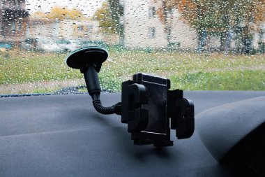 Arabanın ön camında telefonu var. Yakın plan.