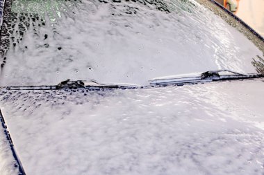 Araba yıkamada köpüklü mavi araba. Yaklaş.