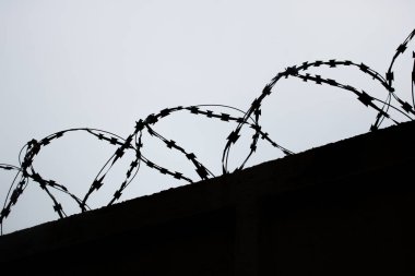 Çitin üzerindeki metal bir tel silueti. Yakın plan.