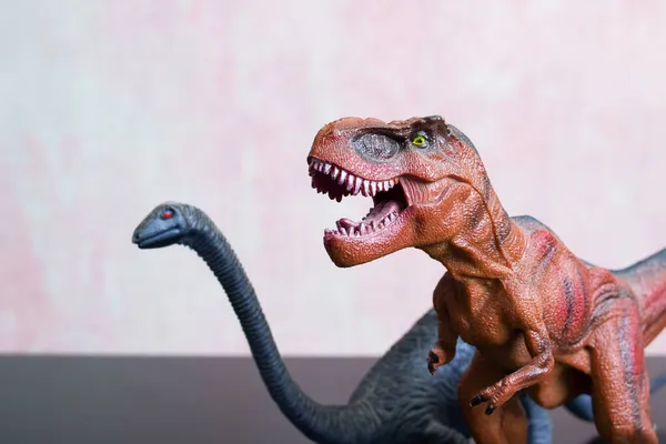 Dois Dinossauros Brinquedo Uma Mesa Madeira Perto — Fotografia de Stock