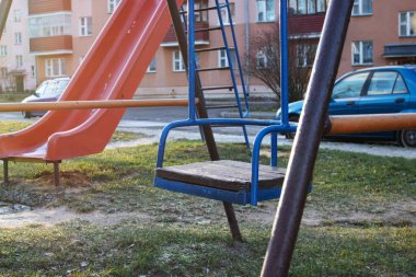 Yaşlı çocuklar avluda salıncakta sallanıyor.