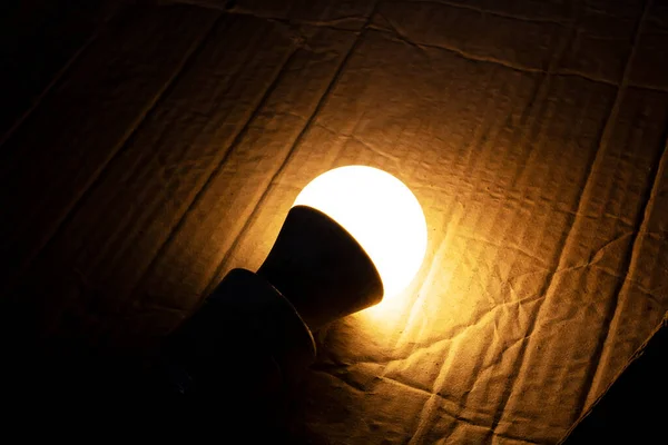 Yellow light bulb glows in the dark —  Fotos de Stock