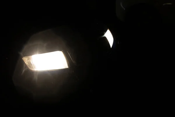 雨の中で暗闇の中で車のヘッドライトを閉じる — ストック写真