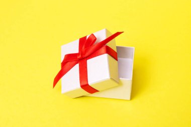 Sarı arka planda bir hediye olan beyaz kutu.