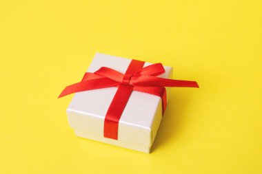 Sarı arka planda bir hediye olan beyaz kutu.