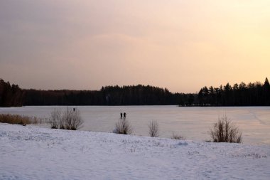 Gün batımında buzun altında karla kaplı göl, doğa.