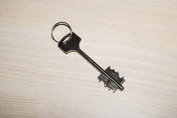 Metal key on a wooden table closeup — Stock Photo, Image