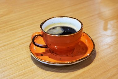 Masada kahve olan kırmızı bardak.