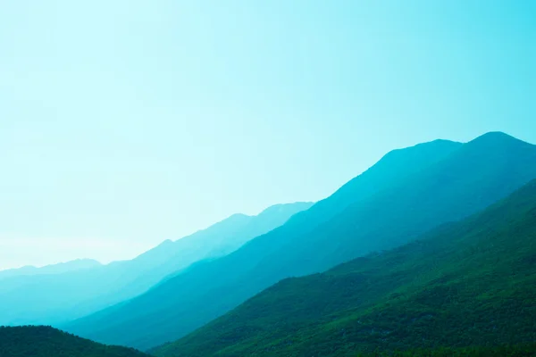 Mountains shrouded in green blue mist — Stock Photo, Image